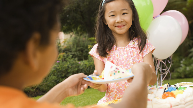 Handing child a slice of birthday cake 