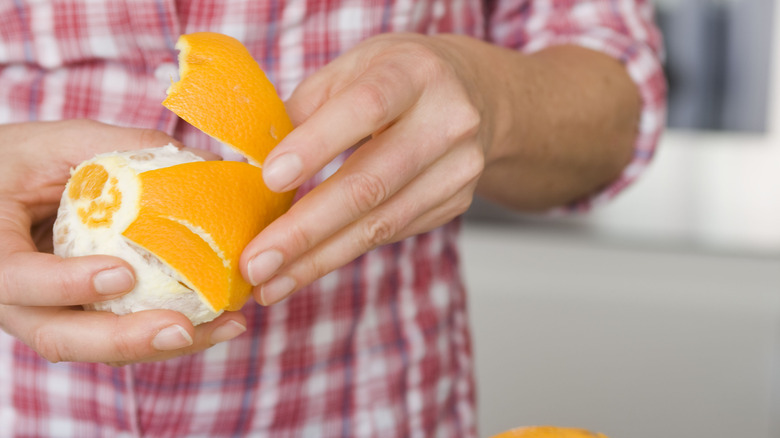 Person peeling orange