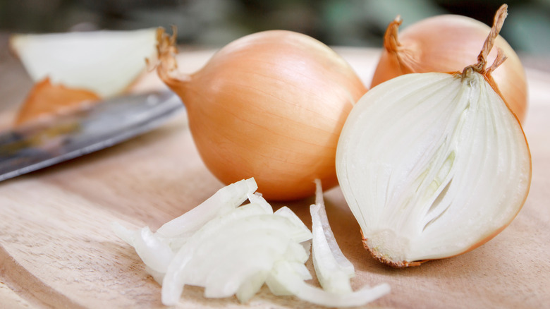 Several sliced onions on a cutting board