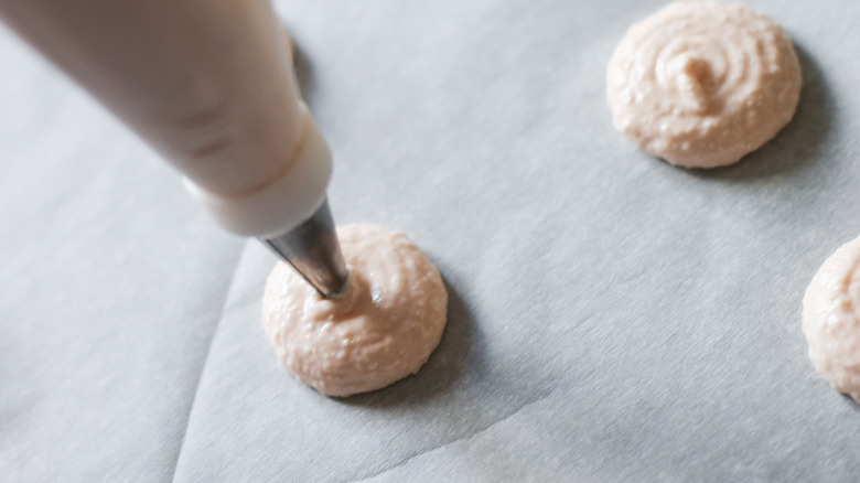 macaron shells piped onto baking sheet