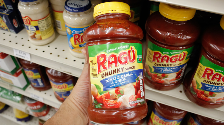 Hand holding jar of Ragu