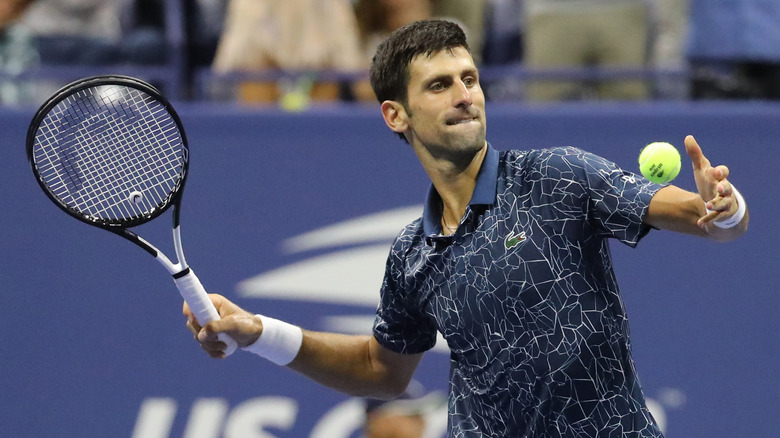 Novak Djokovic serving a tennis ball