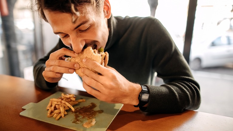 person eating burger and fries