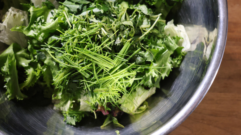 metal bowl of mixed greens and herbs