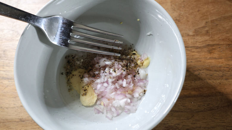 fork in bowl with shallot, mustard, pepper, and vinegar