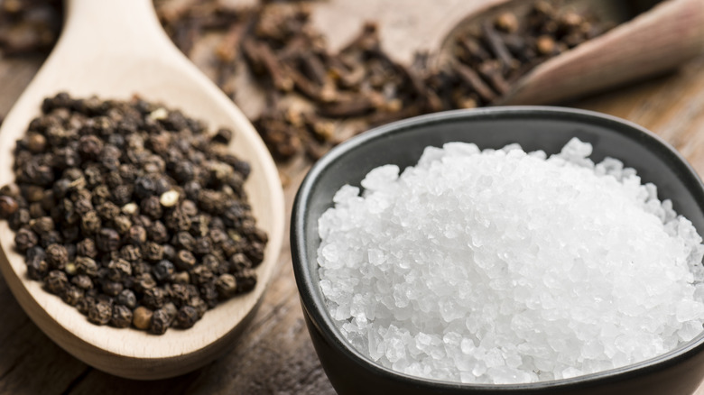 Bowl of salt and wooden spoon with pepper