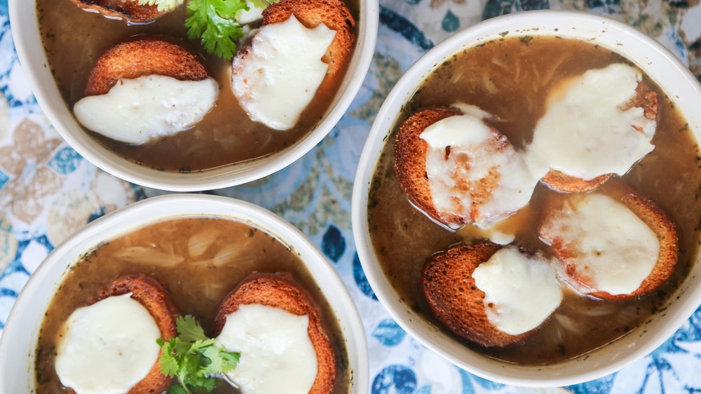 French onion soup in bowl with baguettes and cheese