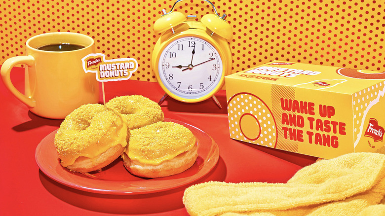 French's mustard donuts with coffee, clock, and robe on red table