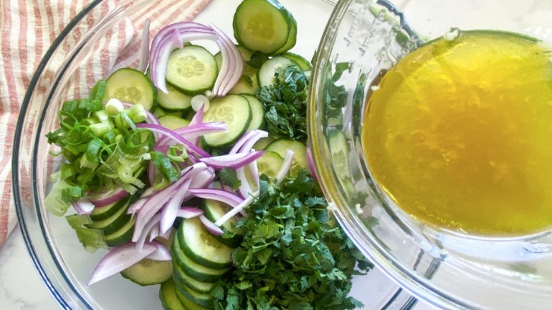 pouring dressing onto vegetable salad