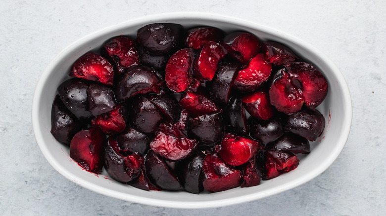 cut plums in baking dish