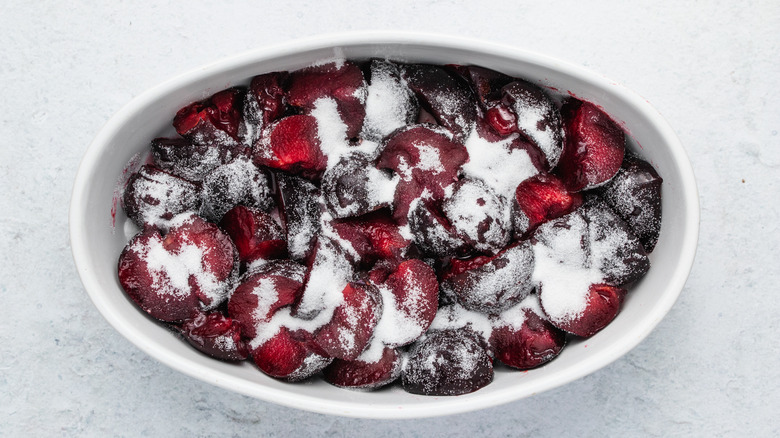 cut plums in baking dish