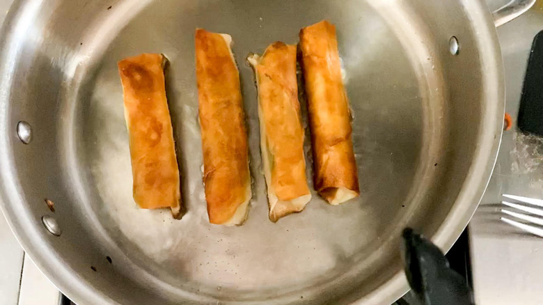 lumpia being fried in pan