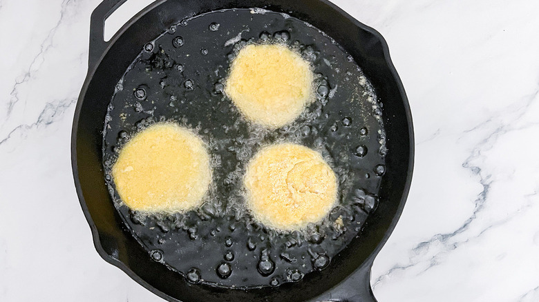 breaded tomatoes in frying pan