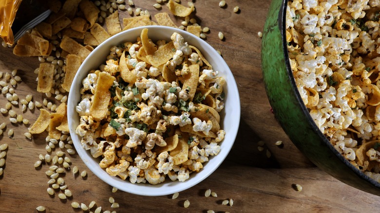 bowl of Frito pie popcorn next to pot of the same on wooden table