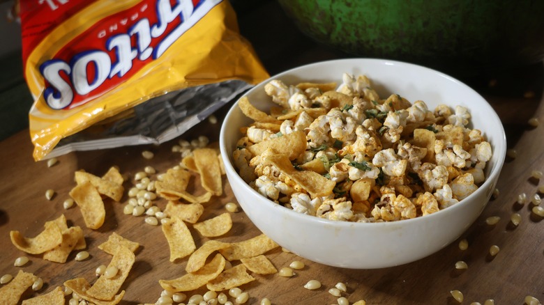 bowl of Frito pie popcorn on table with spilled Fritos chips and popcorn kernels