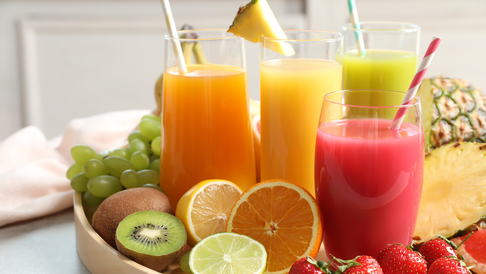 Juice in glasses on fruit-filled tray