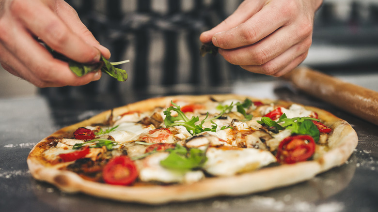 chefs hands preparing italian pizza