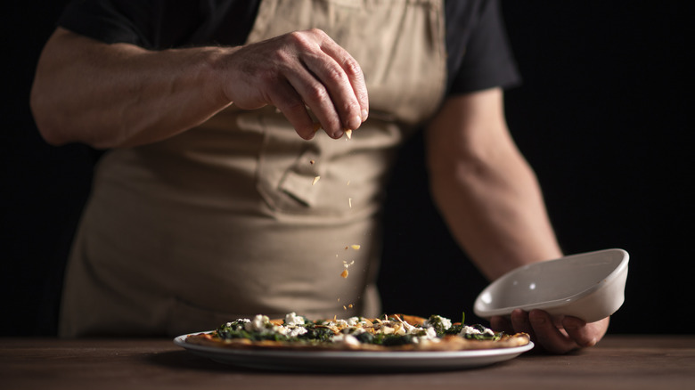 chef decorating pizza