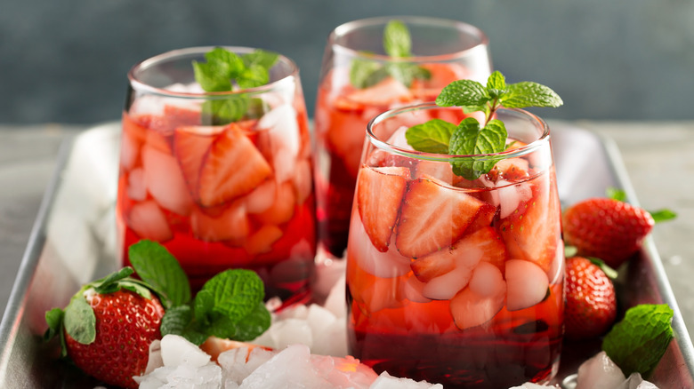 three glasses filled with a strawberry beverage