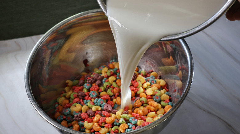 pouring milk into mixing bowl of cereal