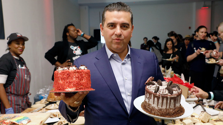 Buddy Valastro holding two cakes