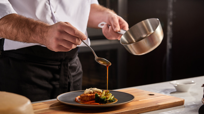 Drizzling sauce on a black plate