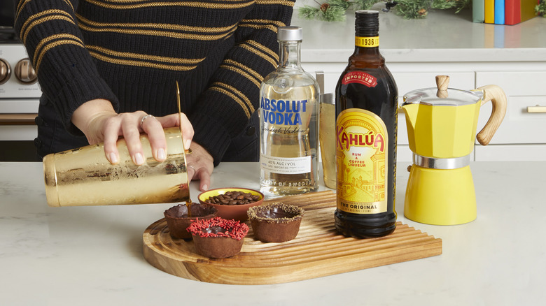 cocktail being poured into cocoa cups 