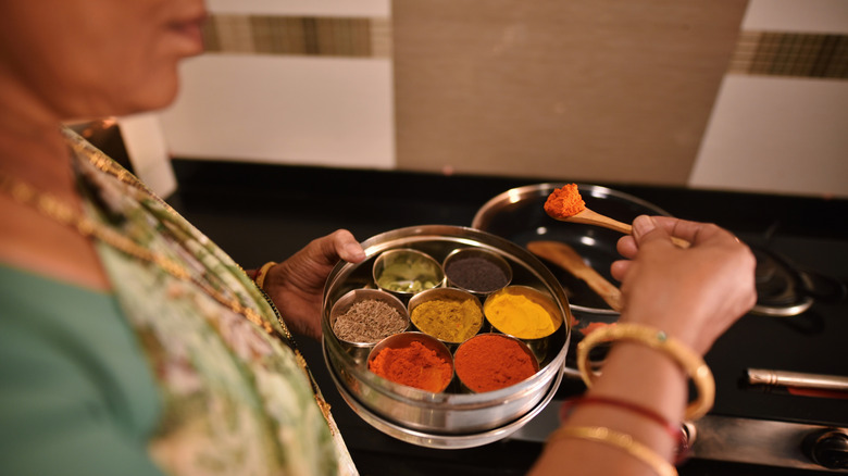 woman using spice box while cooking