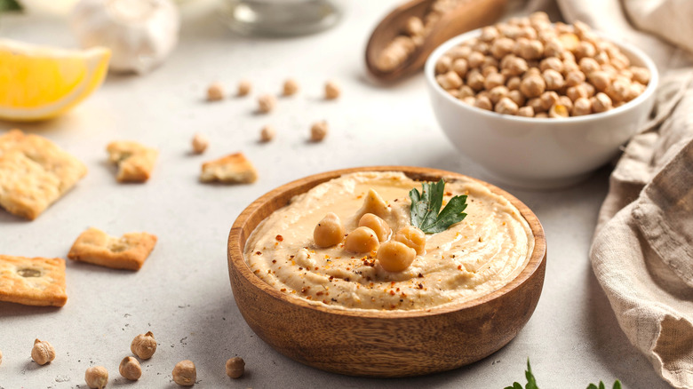 Bowl of hummus and chickpeas on table
