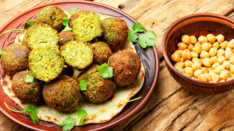 Plate of falafel next to bowl of chickpeas