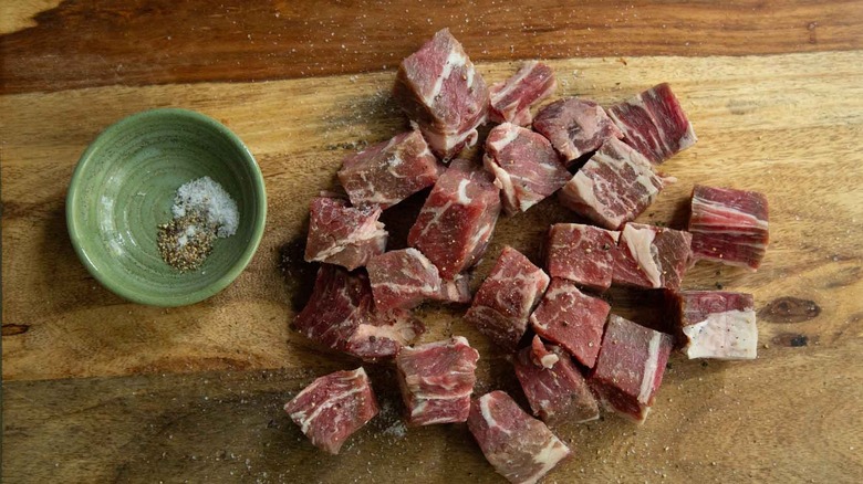 seasoned ribeye cubes on wooden board