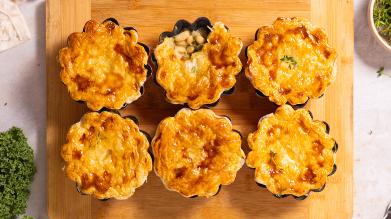 six pot pies on wooden board 