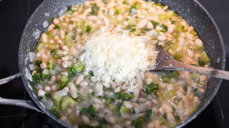 cannellini bean mixture in pan with grated Parmesan cheese