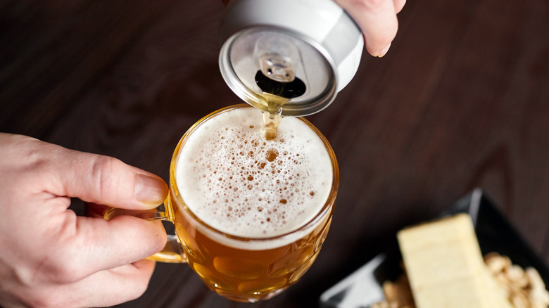 pouring beer can into cup