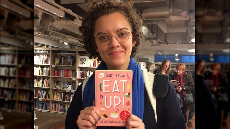 Ruby Tandoh holding one of her books