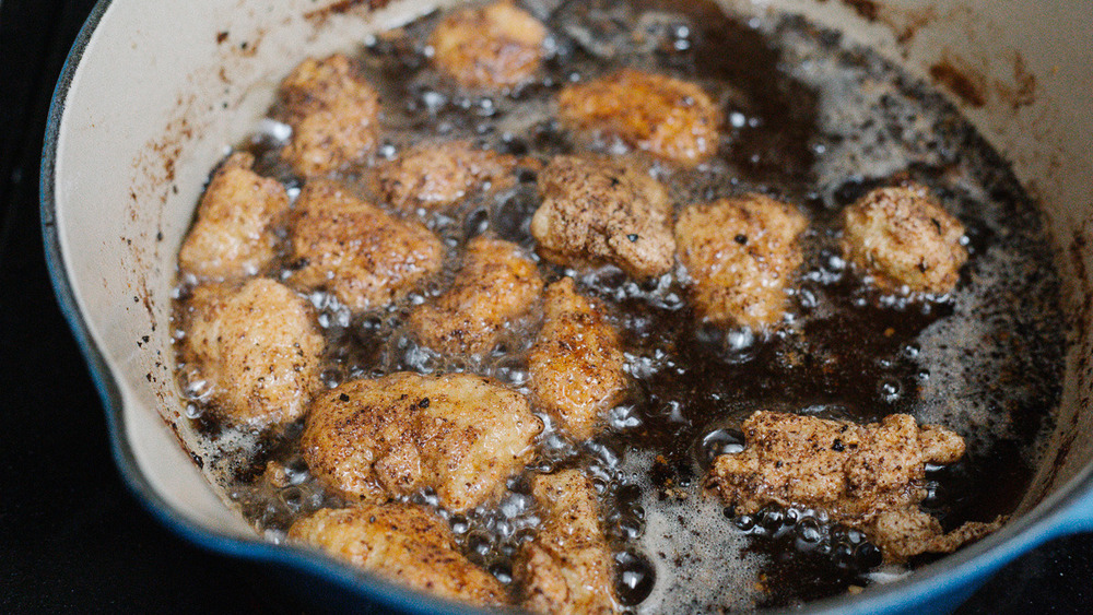 chicken frying in enamel pan