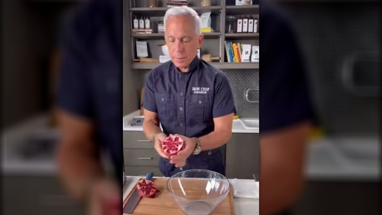 Geoffrey Zakarian working with a pomegranate