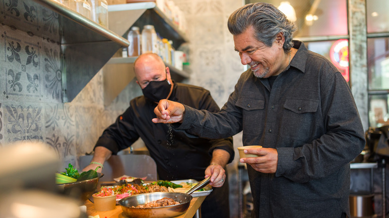 George Lopez sprinkling salt on taco meat 