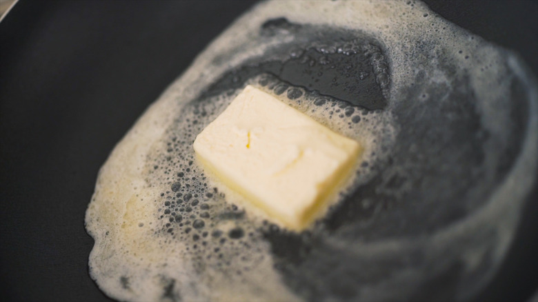 Block of butter melting in a pan