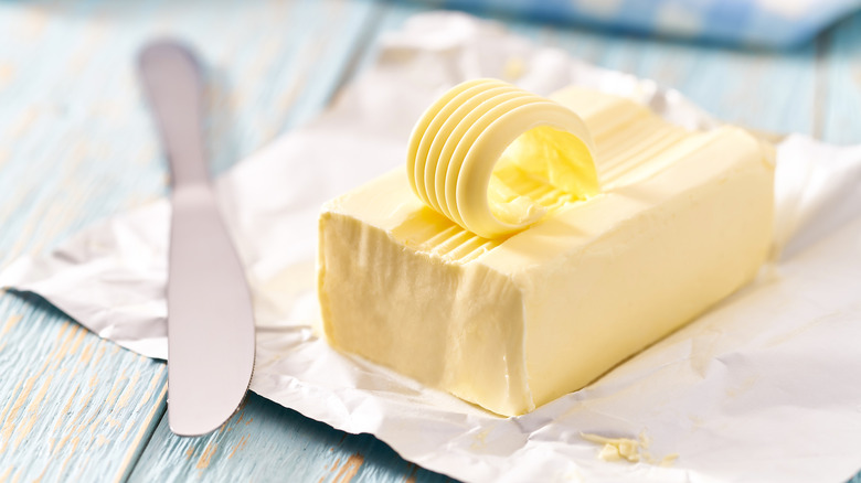 Stick of butter next to a spreading knife