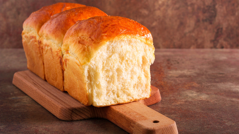 Fresh loaf of white bread on cutting board 