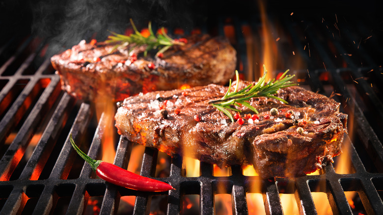 Steaks on the grill with a pepper