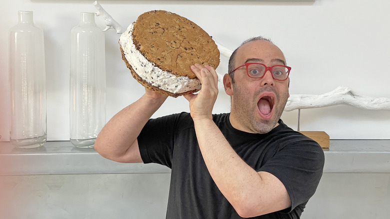 man holding giant cookie ice cream sandwich