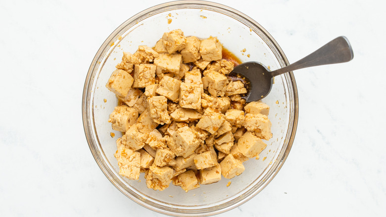 Cubed tofu marinating in bowl