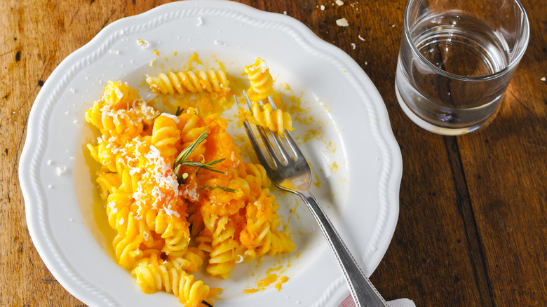 fusilli pasta with pumpkin sauce on plate with fork