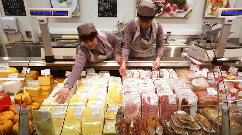 Employees work behind deli counter