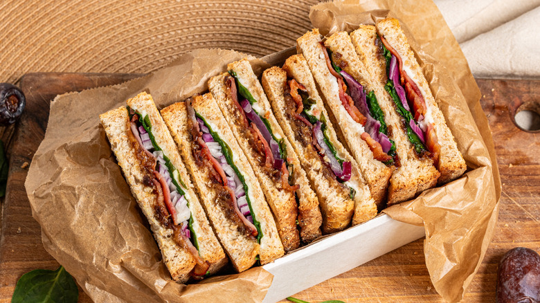 Goat cheese, bacon, and date panini slices in a box