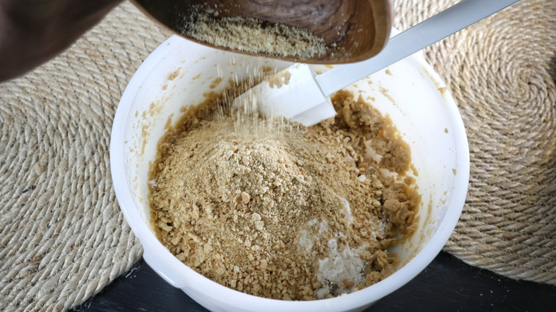 Pouring graham cracker crumbs into bowl