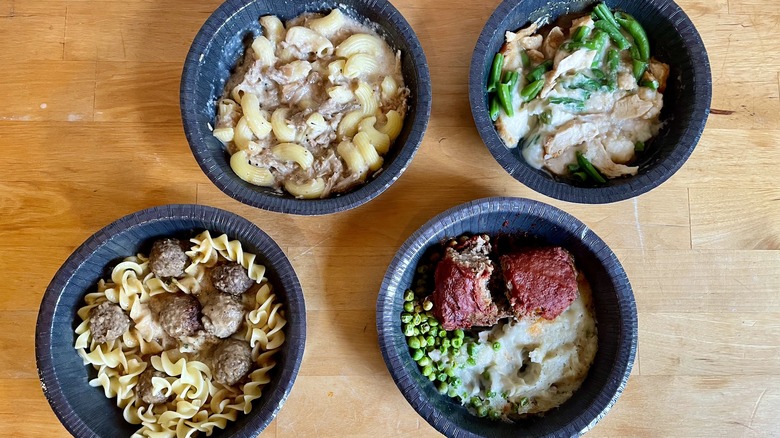 Four cooked microwave meals on table