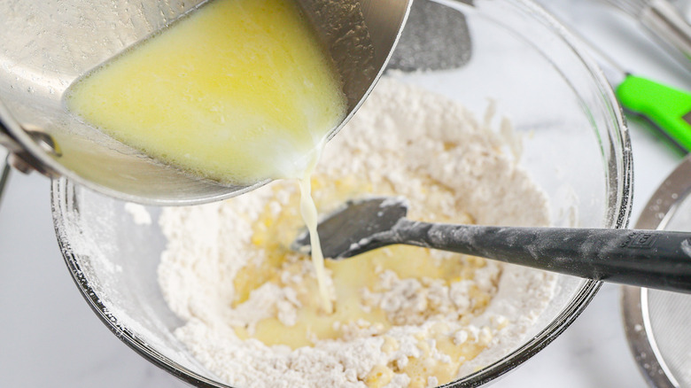 pouring butter into flour mixture